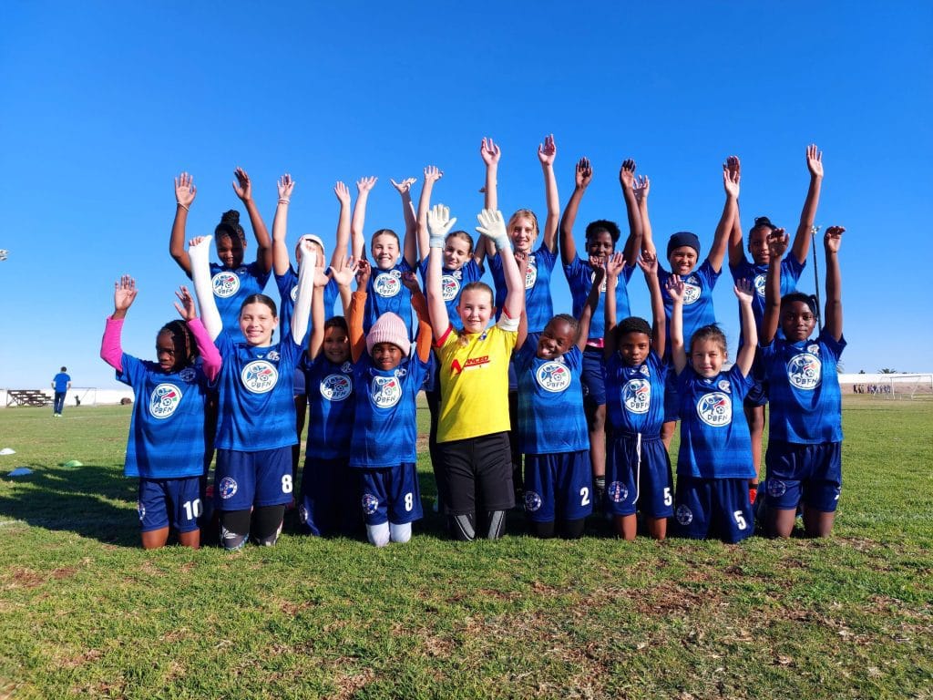 Mannschaftsfoto der ersten Maedchenfussballmannschaft des SFC Swakopmund mit DBFN-Logo